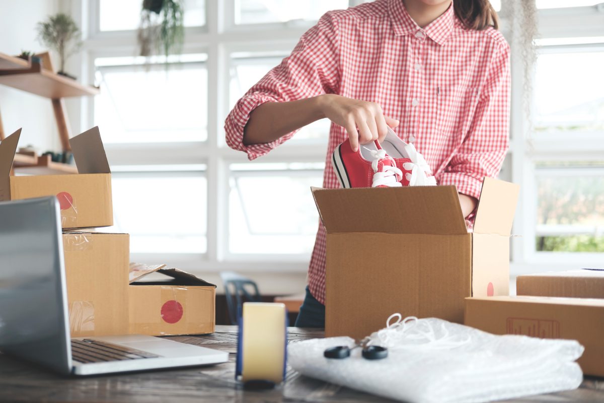 Woman putting shoes in a box.
